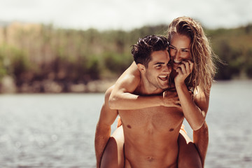Fototapeta premium Couple piggybacking by the lake