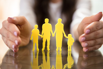 Businesswoman Protecting Family Figures