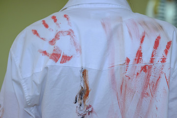 Red prints of hands on back of the shirt