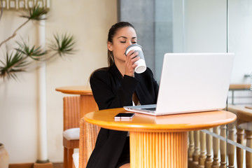 Content woman enjoying coffee while working