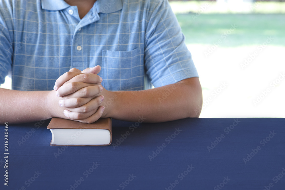 Wall mural young person studing the bible and praying