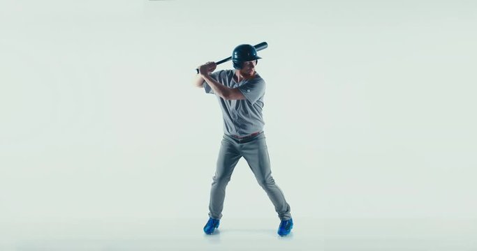 Caucasian professional baseball player batter wearing generic uniform posing as if he was hitting a ball isolated on white background. 4K UHD 60 FPS SLOW MOTION