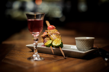 Red cocktail and delicious snack on the table