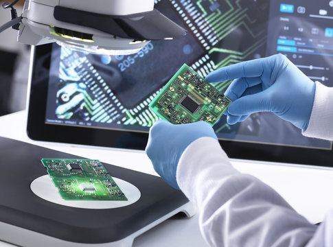 Engineer using a d stereo microscope for quality control in the manufacturing of circuit boards for the electronics industry