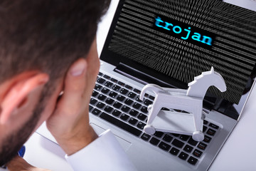 Businessman With Laptop Screen Showing Trojan Text