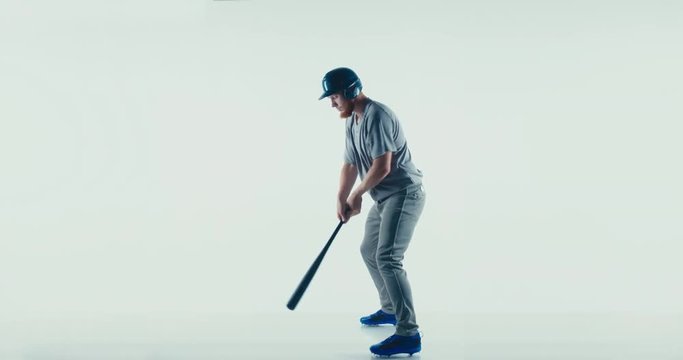 Caucasian professional baseball player batter wearing generic uniform posing as if he was hitting a ball isolated on white background. 4K UHD 60 FPS SLOW MOTION