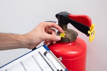 Man Checking Symbol On Fire Extinguisher