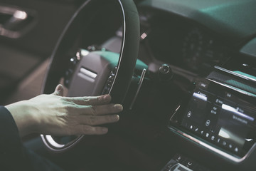 Man hand on a steering wheel of a modern car