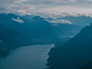 Naklejka premium view from the peak of mountain to a blue lake covered in clouds, brienzer rothorn switzerland alps