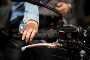 Woman's hand on a motorcycle handlebar