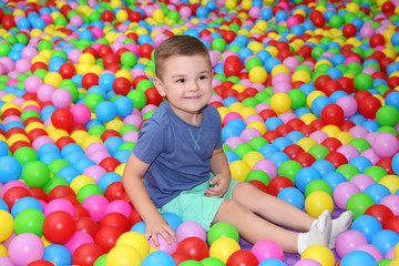 Fototapeta na wymiar Cute boy playing among plastic balls