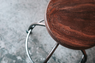 Wood and metal backless bar stool on grey concrete floor. Loft minimalism design ideas for...