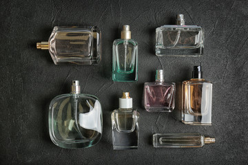 Perfume bottles on dark background, flat lay