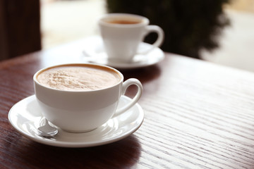 Cup of delicious aromatic coffee on table