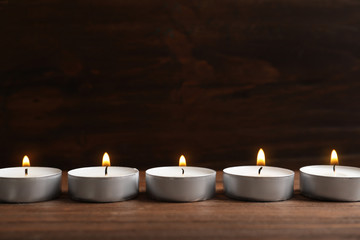 Fototapeta na wymiar Small wax candles burning on wooden table
