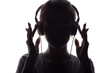 silhouette of a girl listening to music in headphones