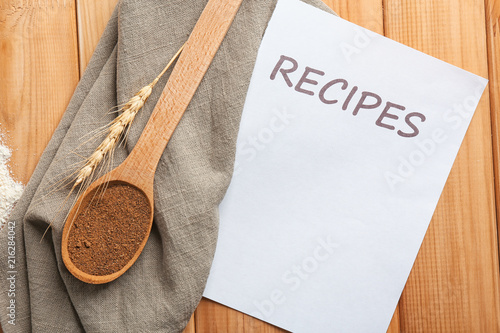 paper sheet with word recipes and spoon of coriander for word recipes