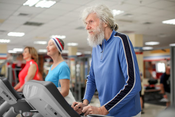 Fototapeta na wymiar Group of elderly people training in modern gym