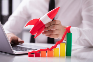 Rocket Beside Multi Colored Graph With Arrow