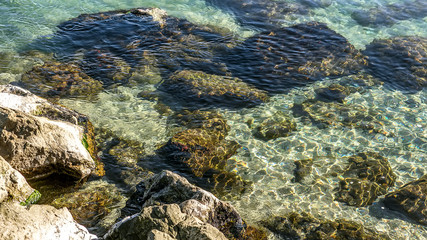 Stones in clear sea water on a sunny day