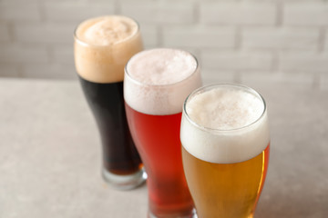 Glasses with different types of cold tasty beer on table, closeup