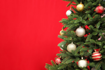 Beautifully decorated Christmas tree against color background, closeup