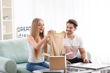 Young couple unpacking parcel at home