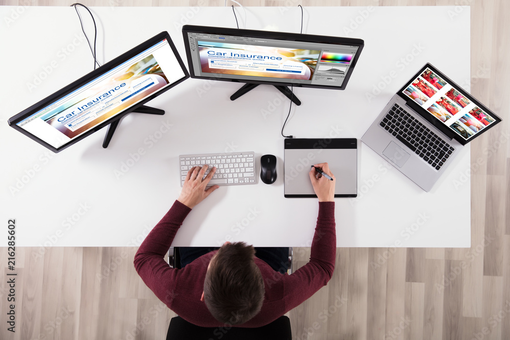 Poster designer making web page design on computer using graphic tablet