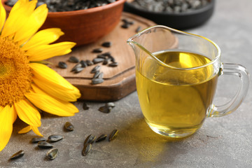 Jug with sunflower oil on table, closeup