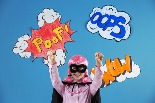 Cute girl as superhero on color background