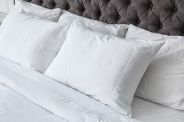 Fototapeta na wymiar Soft white pillows on comfortable bed, closeup