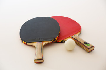 tischtennisschl&auml;ger und ball  liegen auf wei&szlig;em grund