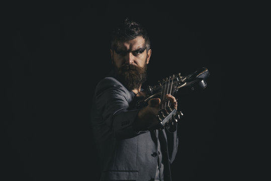 Music party and entertainment. Man go to music party. Bearded man with guitar ready to play at music party. Guitarist with musical instrument at music party. Rock is alive