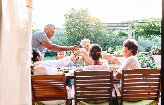 Three generations one family  have dinner in summer garden