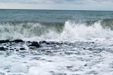 Beautiful waves of the sea foaming breaking at the beach