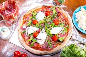 close up of delicious italian pizza with ham, mozzarella and tomatoes