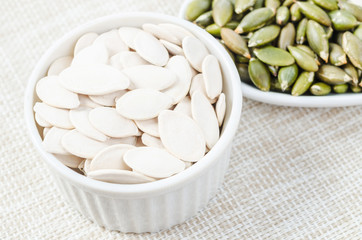 Pumpkin seeds in white bowl.