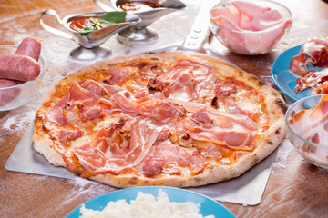 close up of tasty pizza with sausage, ham and meat
