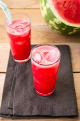 Watermelon smoothies on a black napkin and wooden background, cocktail, cold drink