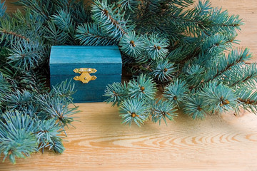 Natural style of christmas background with wooden chest and spruce branches on a wooden background
