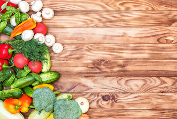 Border from different vegetables on wooden background. Top view. Space for text.