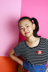 The bust of a lovely healthy oriental girl. Behind the pink background