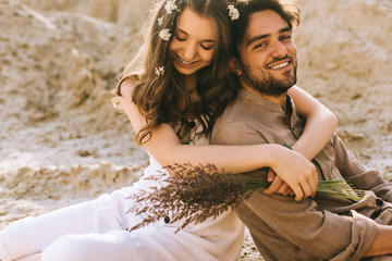 beautiful girl with flowers in hair embracing her happy boyfriend