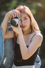 Portrait of asian woman is a professional photographer with mirrorless camera, outdoor portrait, free from copy space.