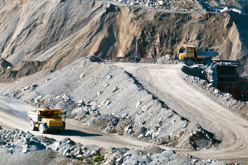 Open-pit mine with dump trucks.Heavy mining dump trucks driving along the opencast.Quarry ore.