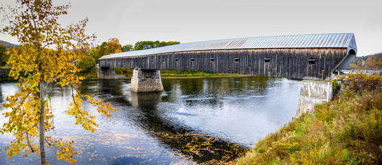 The Cornish-Windsor Covered Bridge, the longest covered wooden bridge of the USA, spans the Connecticut River between the towns of Cornish, New Hampshire, and Windsor, Vermont. - obrazy, fototapety, plakaty