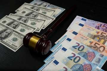 Judge's gavel on the background of euro and dollar bills