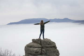 Obraz premium the girl from the back on the cliff