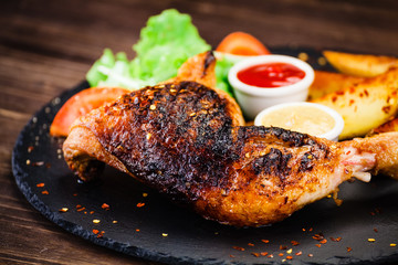 Grilled chicken legs with baked potatoes and vegetables 