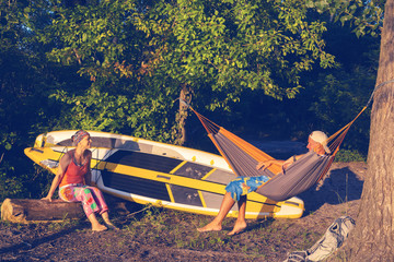 Couple of sup surfers is relaxing in a river camping